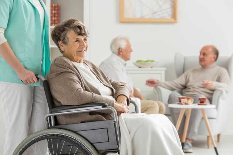 Nurse reviewing a medication list and care plan with an older resident at a table